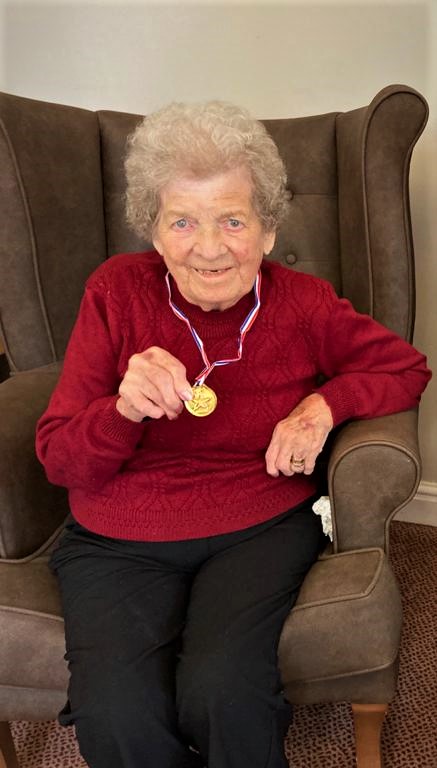 New resident, Beryl holding medal